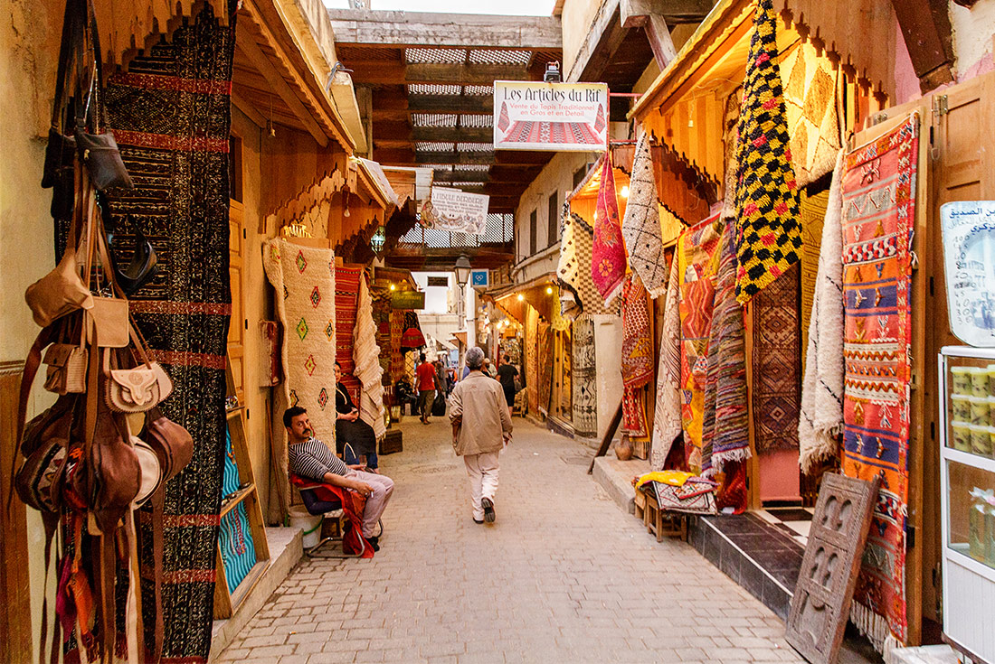 Local man walks through market street, Fes, Morocco