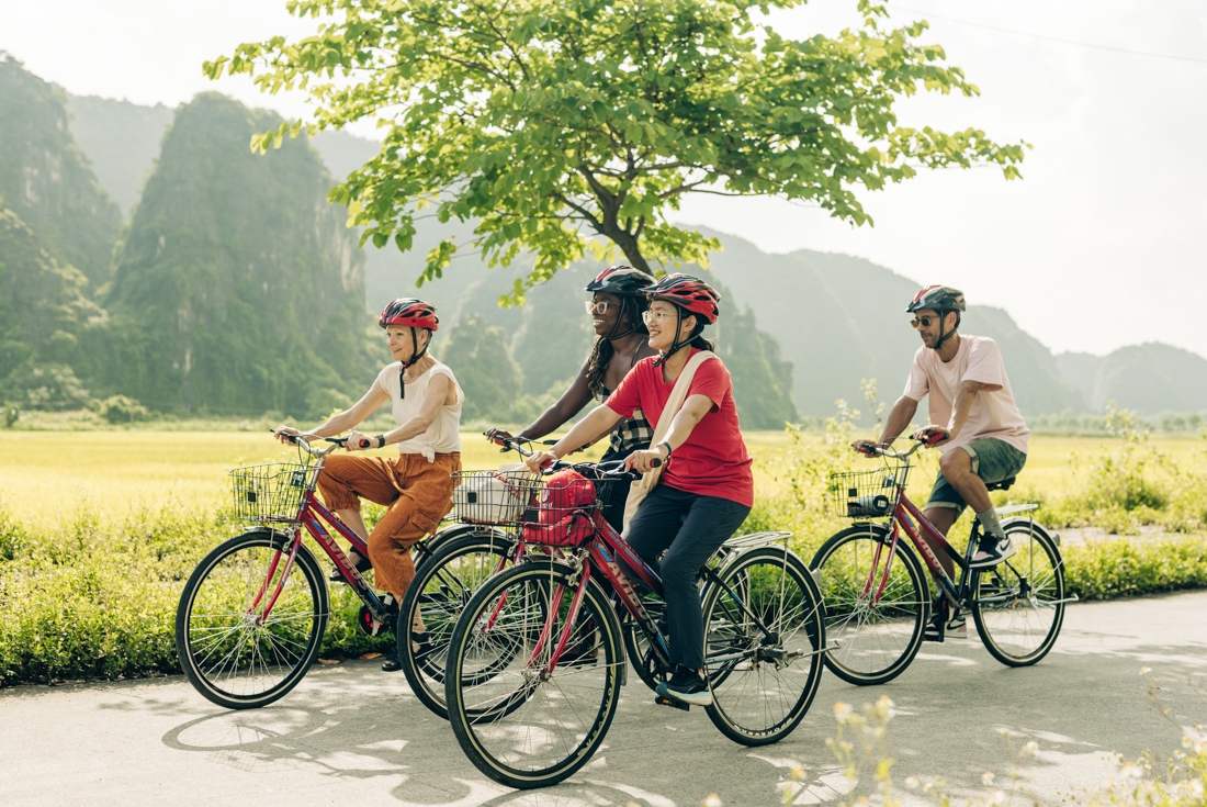 Group of Intrepid travellers and leader go cycling in Ninh Binh