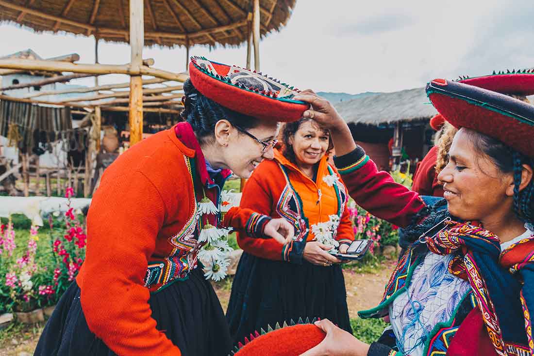 Travellers try on traditional clothing with local in Sacred Valley
