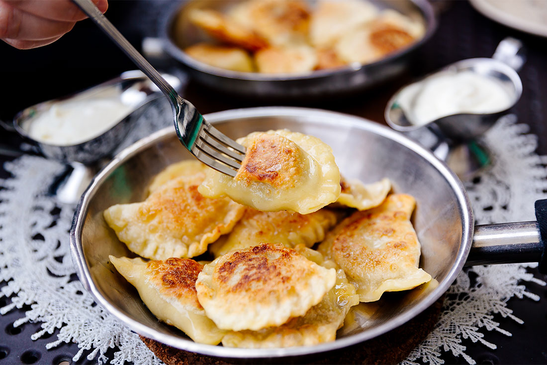 Traveller going to take one from a plate of traditional Polish pierogies