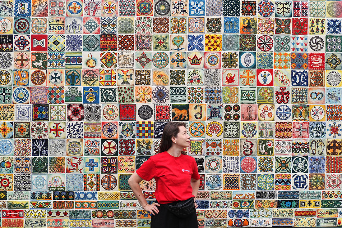 Intrepid leader stands in front of Gori mosaic mural