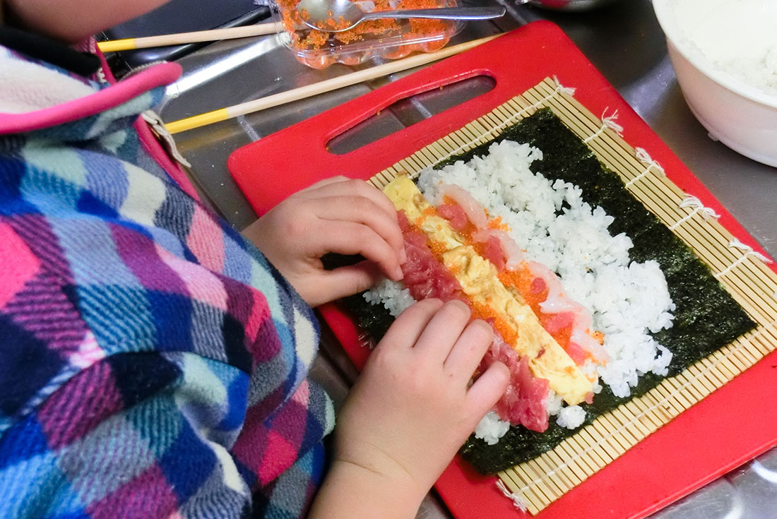 Girl making sushi, Japan