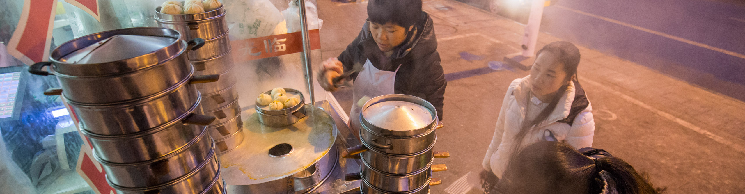 Woman serving food at the Chengdu night markets , China 