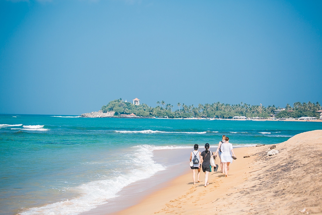 Intrepid travellers walking along the Unawatuna Beach in Galle, Sri Lanka