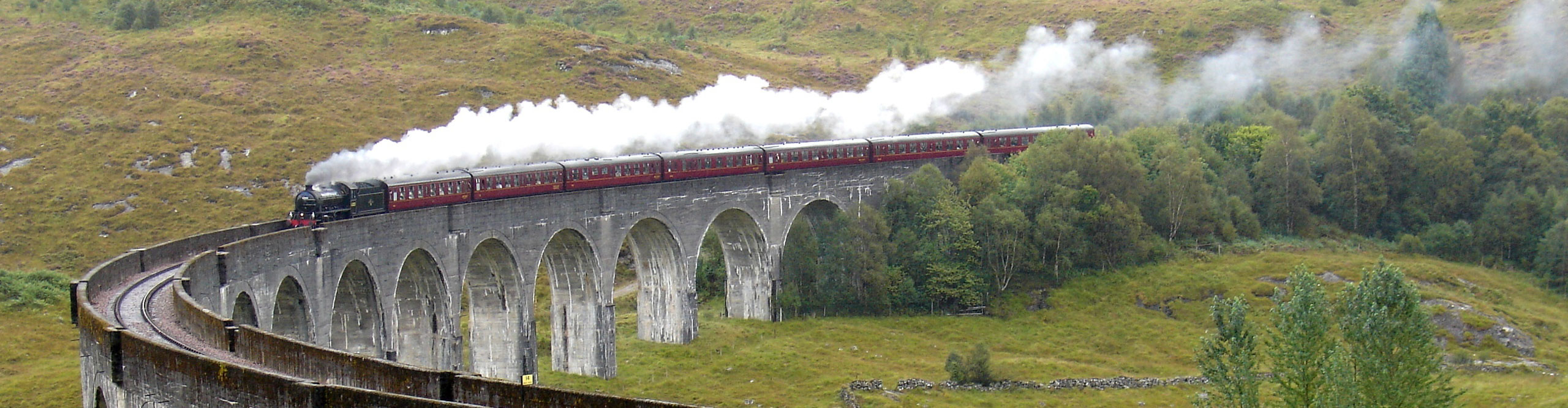 steam train on viaduct in the hills of Scotland
