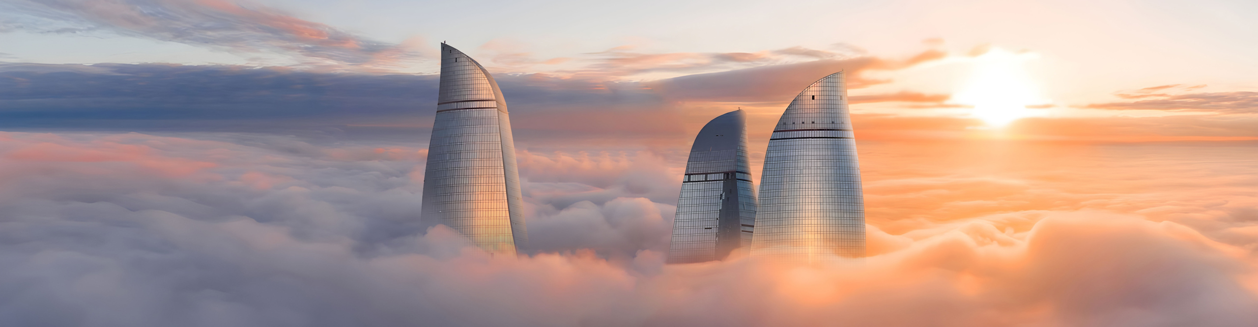 Flame towers among the clouds, Baku, Azerbaijan at sunset amongst orange clouds