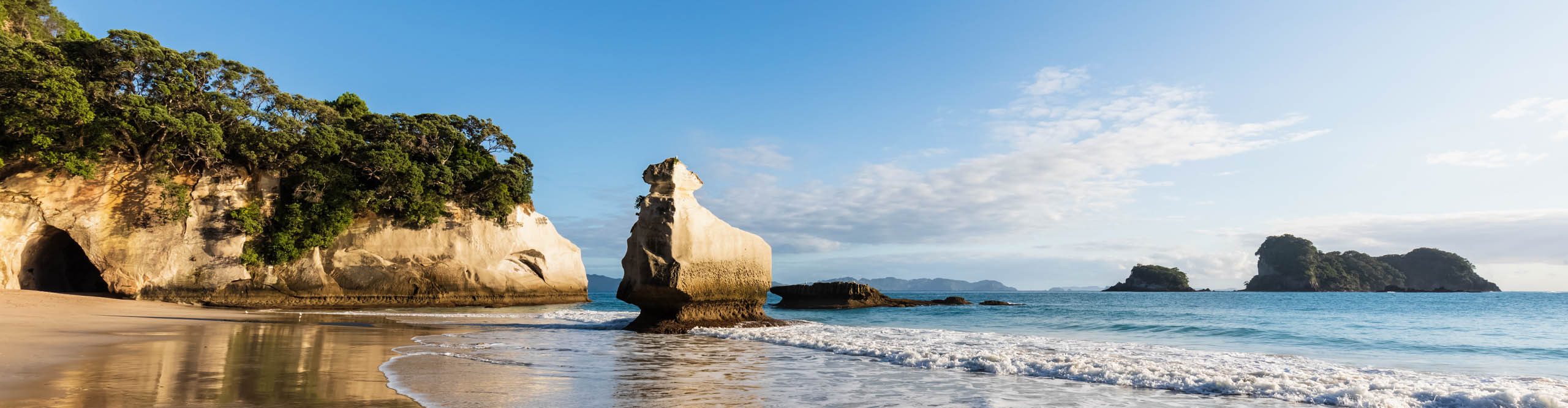 Smiling Sphinx Rock with waves crashing in the late afternoon sun, Cathedral Cove, New Zealand 