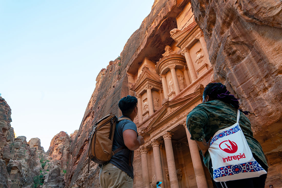 Intrepid travellers look up at the carved facade of Petra in Jordan