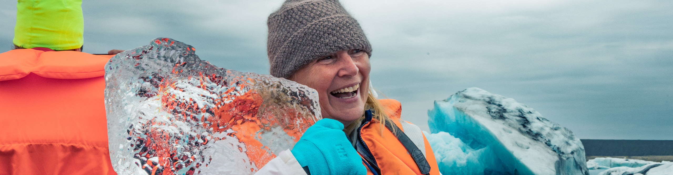 Woman holding a block of ice and laughing in Iceland 