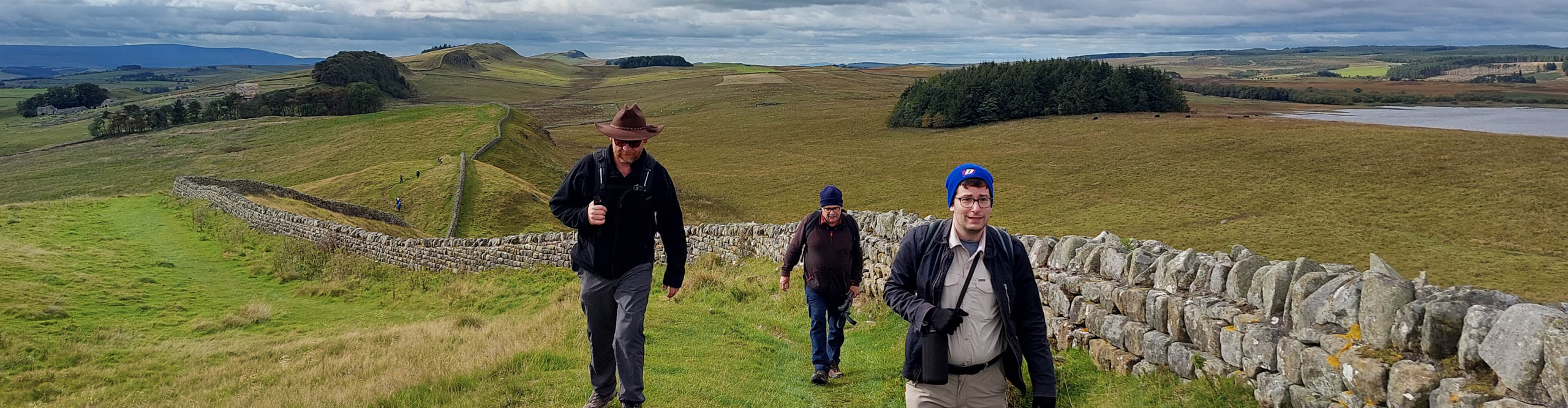  Hikers at Hadrians Wall on a cloudy day, Northumberland, England