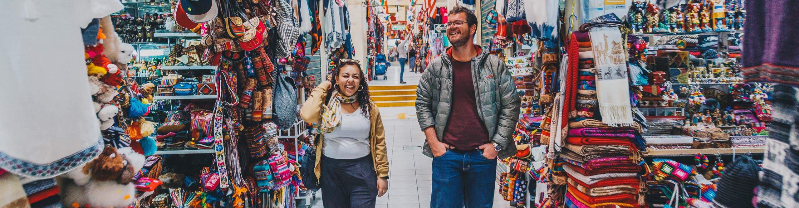 Travellers walking through the colourful markets of Cusco, Peru