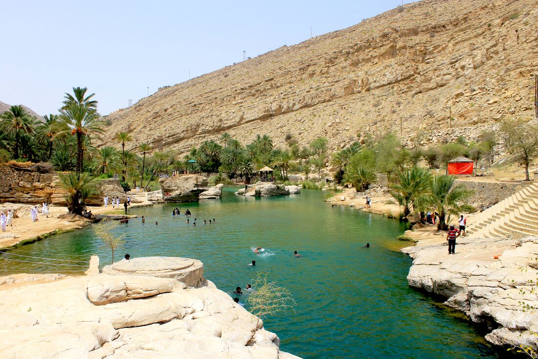 Travellers and locals swim in the crystal waters of the Wadi Bani Khalid oasis in Oman