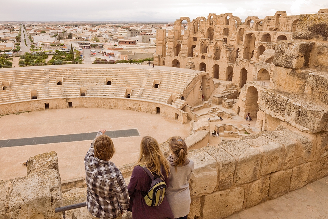 Family looks over Roman colliseum ruins, El Jem, Tunisia