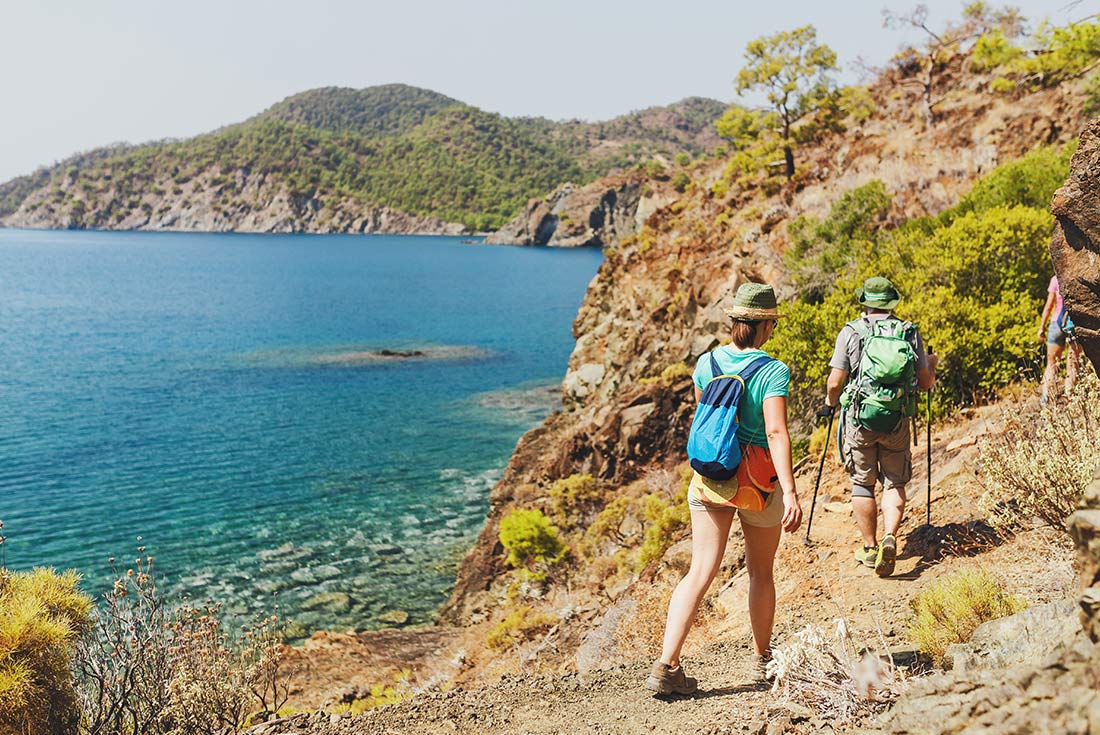 Travellers hiking along the Lycian Way with blue waters in the background, Turkey