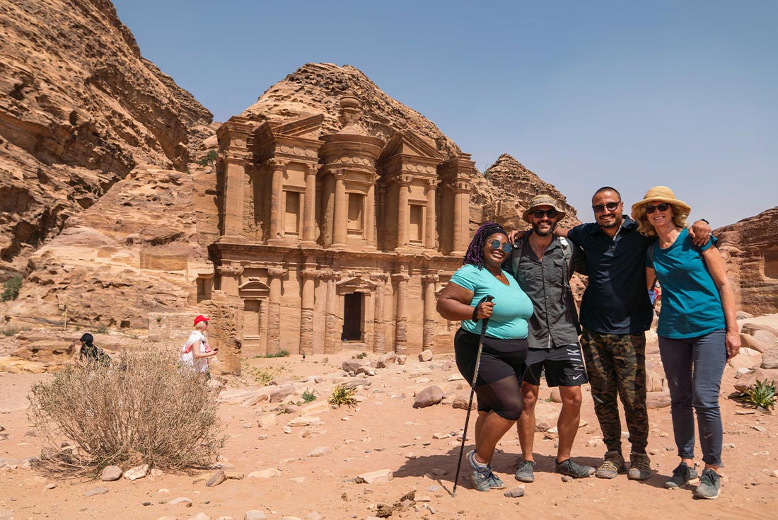 Travellers pose in front of Petra, Jordan with their leader