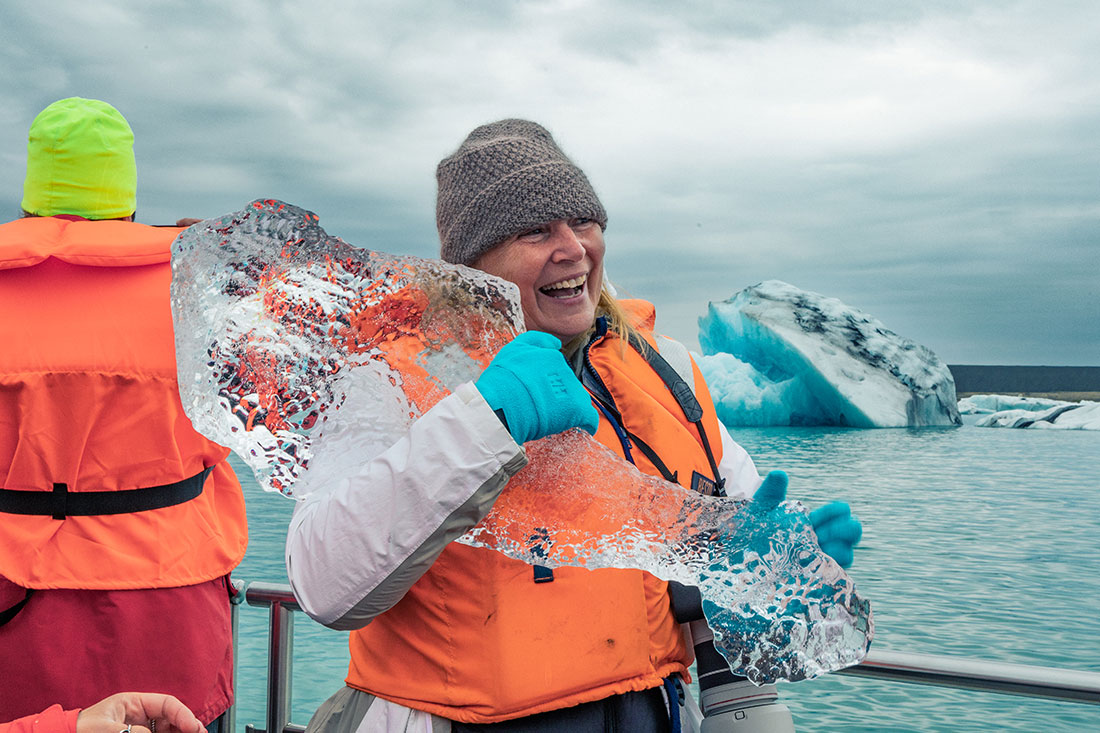 Traveller holding ice shard on Jokulsarlon Glacier Lagoon Boat Tour