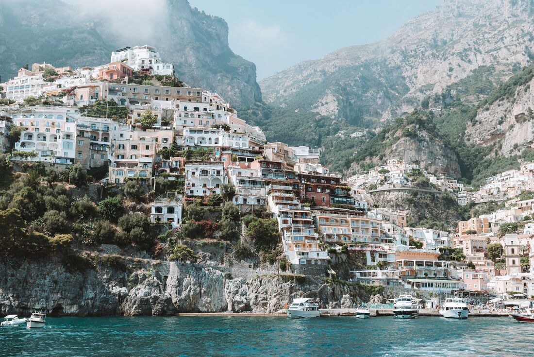 View of buildings of Minori town stacking up the hill-topped cliffs of Minori town on the Amalfi Coast, from the water