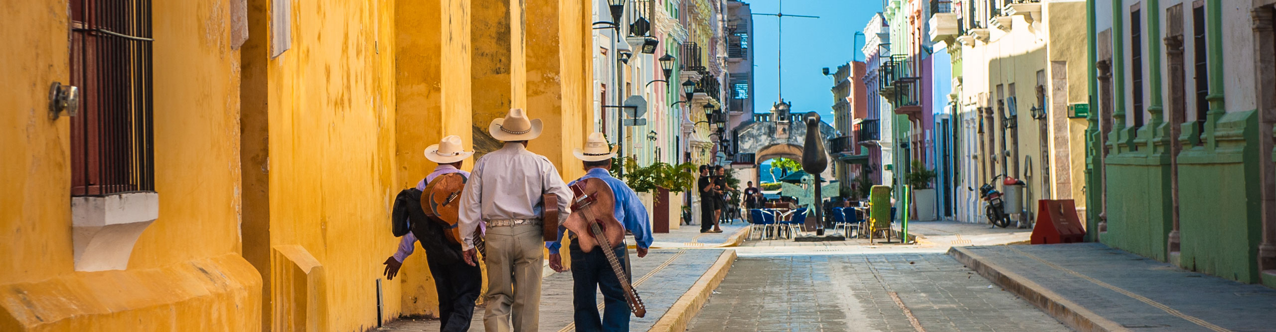 Mariachi band walking on the streets of colonial, with yellow buildings, Campeche city, Mexico