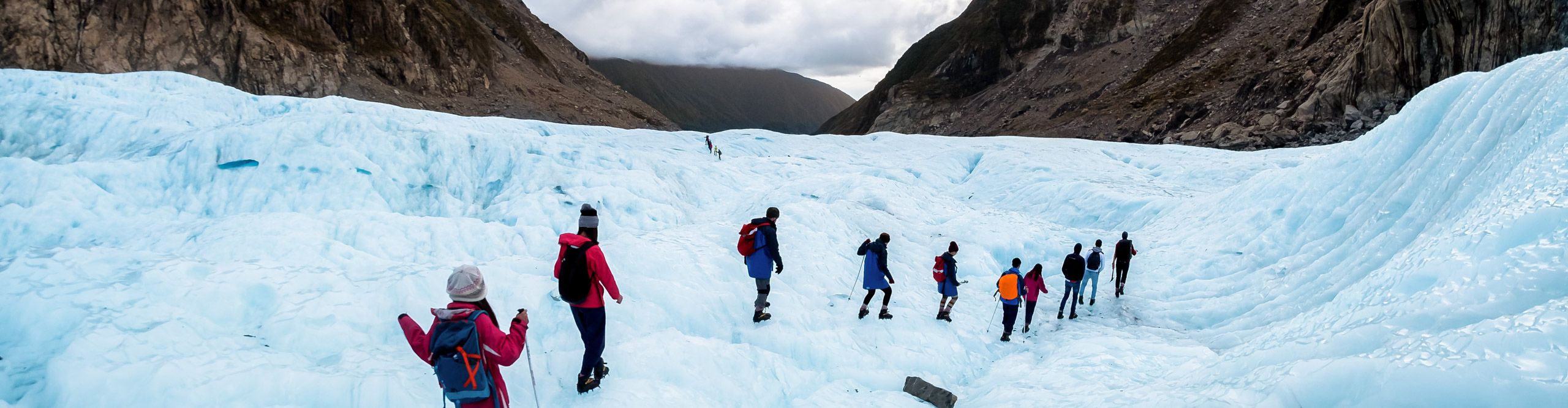 Hikers and travelers walking on ice in Fox Glacier, New Zealand. 