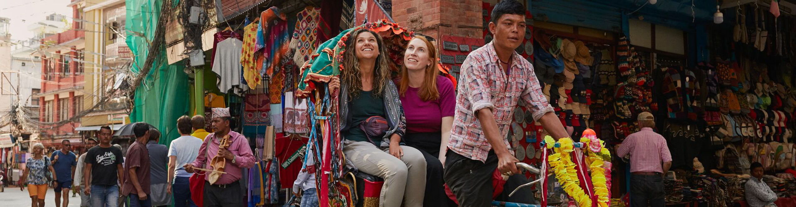 Women on colourful tuk tuk ricin through Katmandu, Nepal 