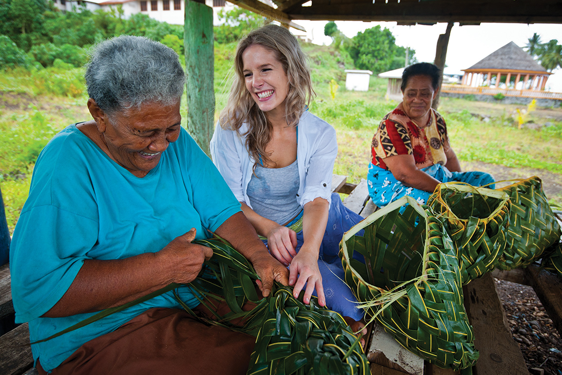 Customer learning to weave baskets the Samoan way (Fa'a) with two smiling locals