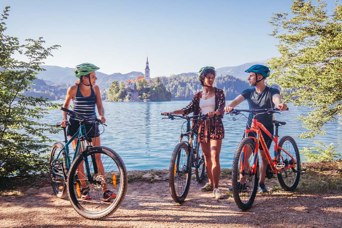 Travellers cycling in front of Lake Bled, Slovenia