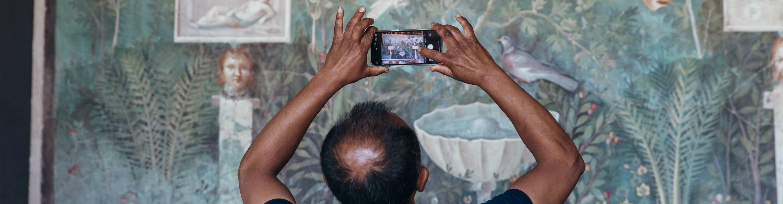Man taking pictures  or artwork in a museum with mobile, Rome, Italy 