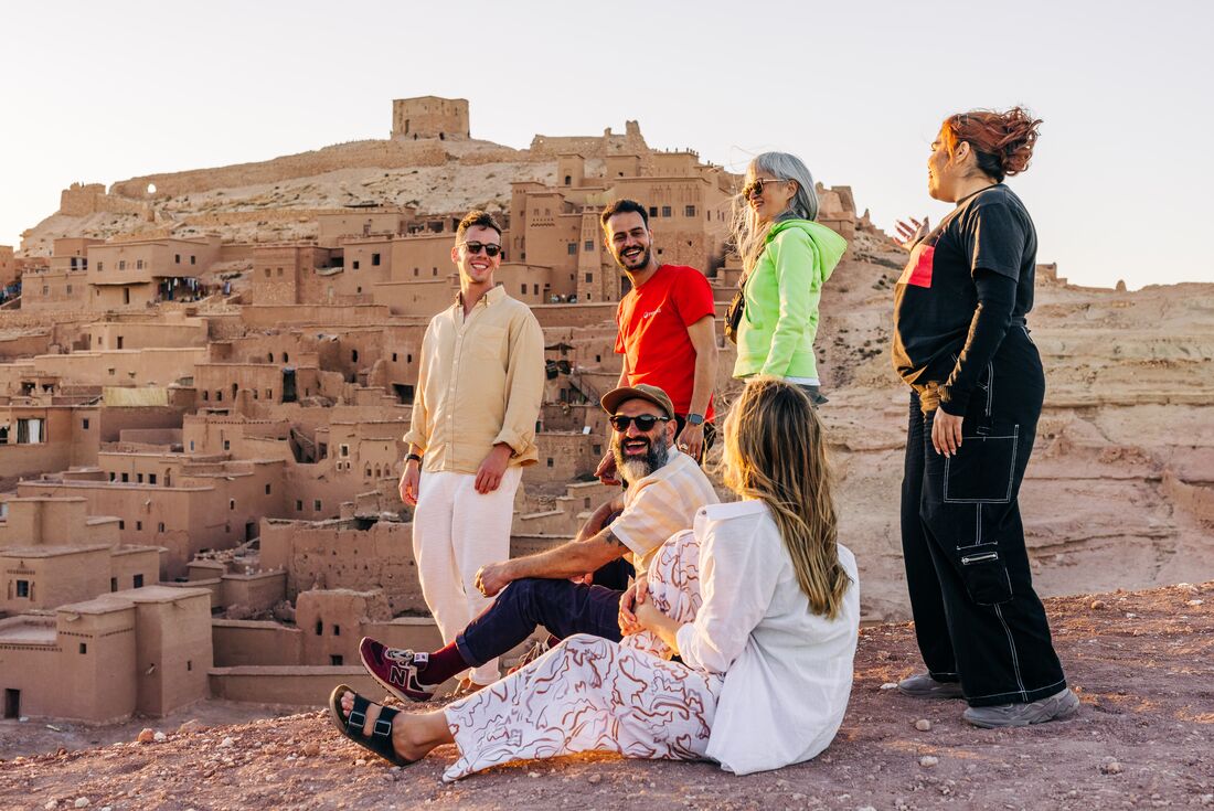 Intrepid travellers and leader on the crest of a hill overlooking Ait Benhaddou