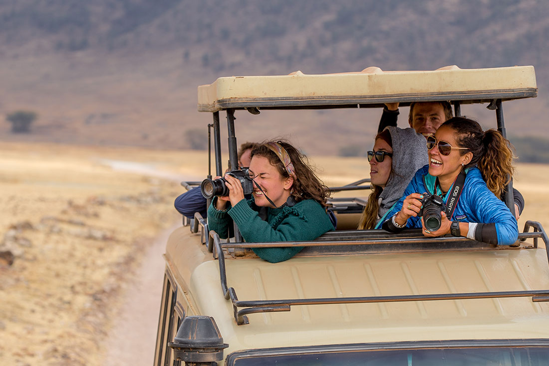 Travellers photographing wildlife on safari in Ngorongoro Conservation Area