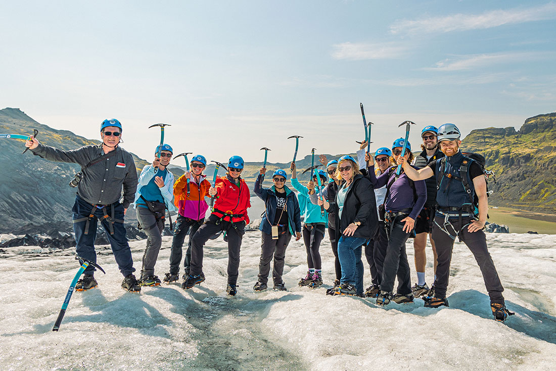 Group raise pickaxes in joy before commencing Sólheimajökull Glacier Walk