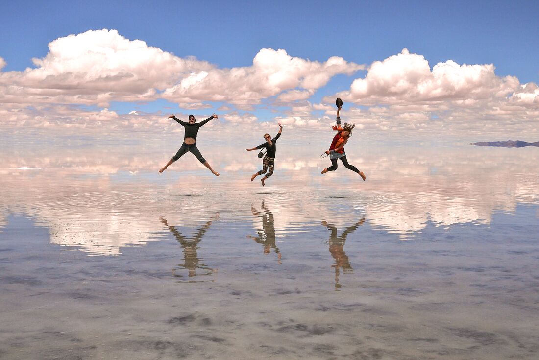 Travellers jumping on the salt flats of salar de uyuni, Bolivia