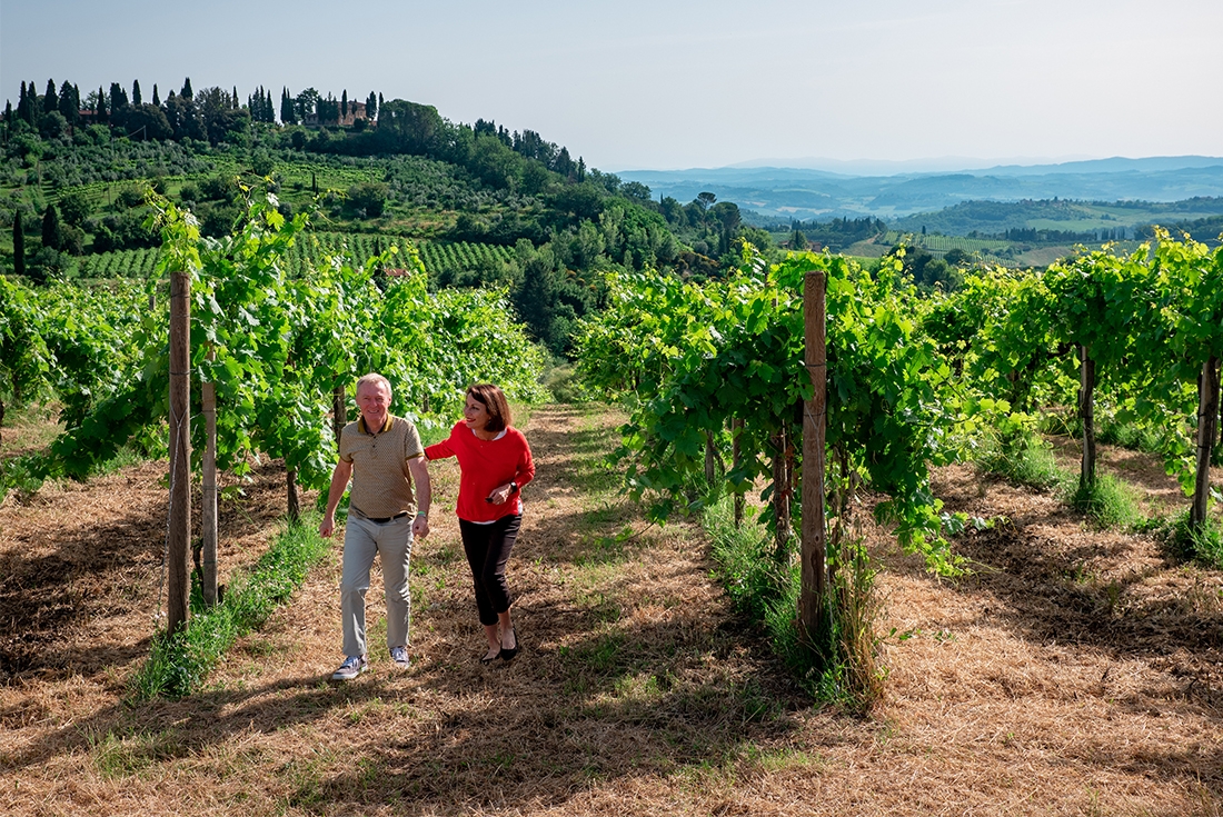 A traveller couple touring a vineyard in Tuscany, Italy.