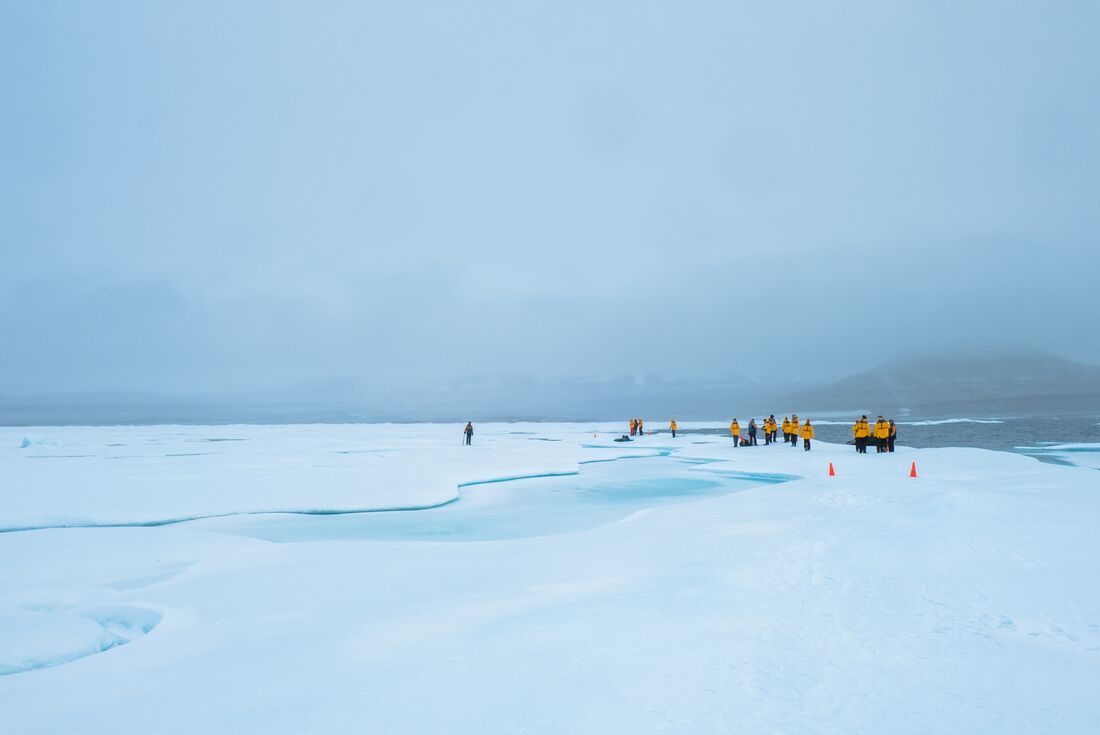 Travellers walking across ice in Lancaster Sound