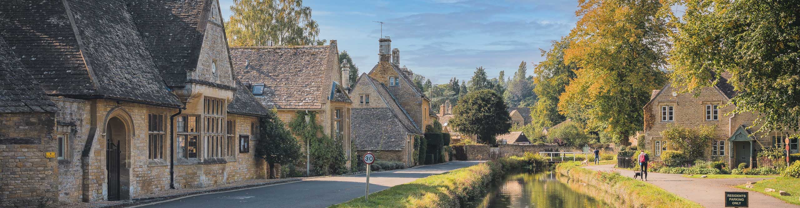 Stone cottages alongside a small rive in the Cotswolds, England 