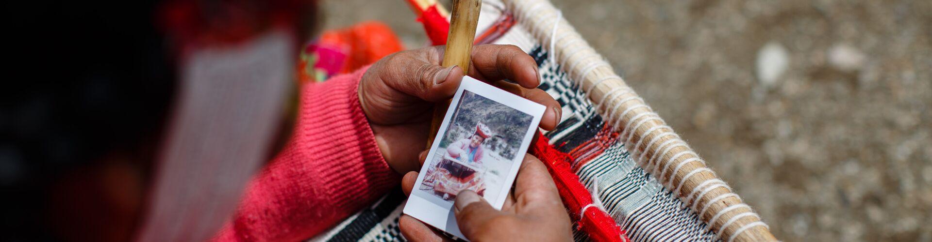 Hand holding a polaroid picture of Peruvian woman