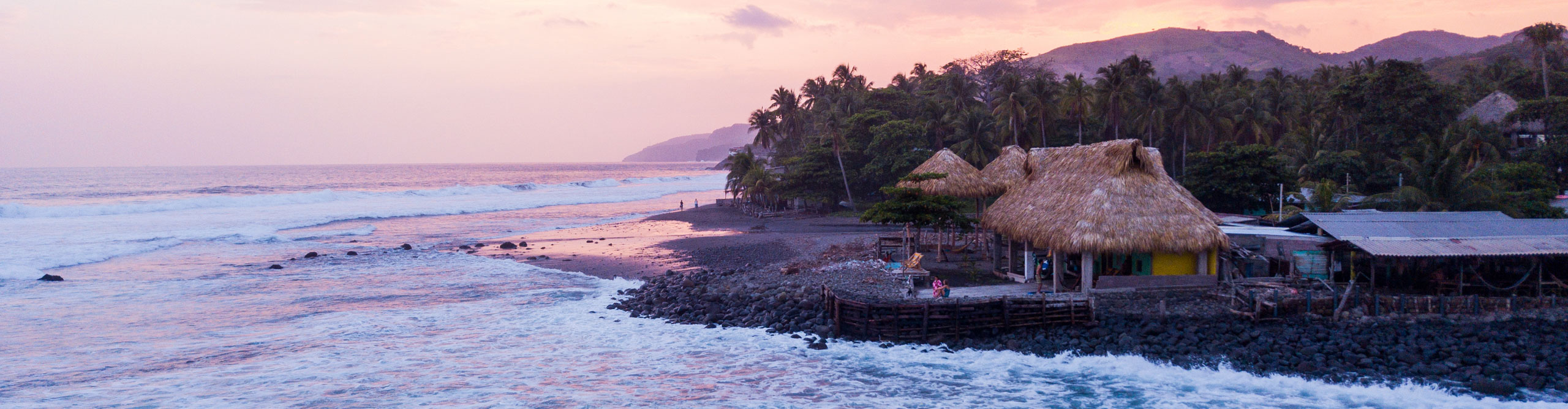 Sunset along the coastline with waves crashing and a pink sky in El Salvador near El Zonter