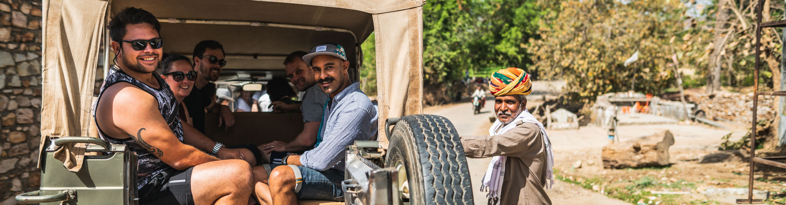Group sitting in truck in the sunshine in Bijaipur, India 