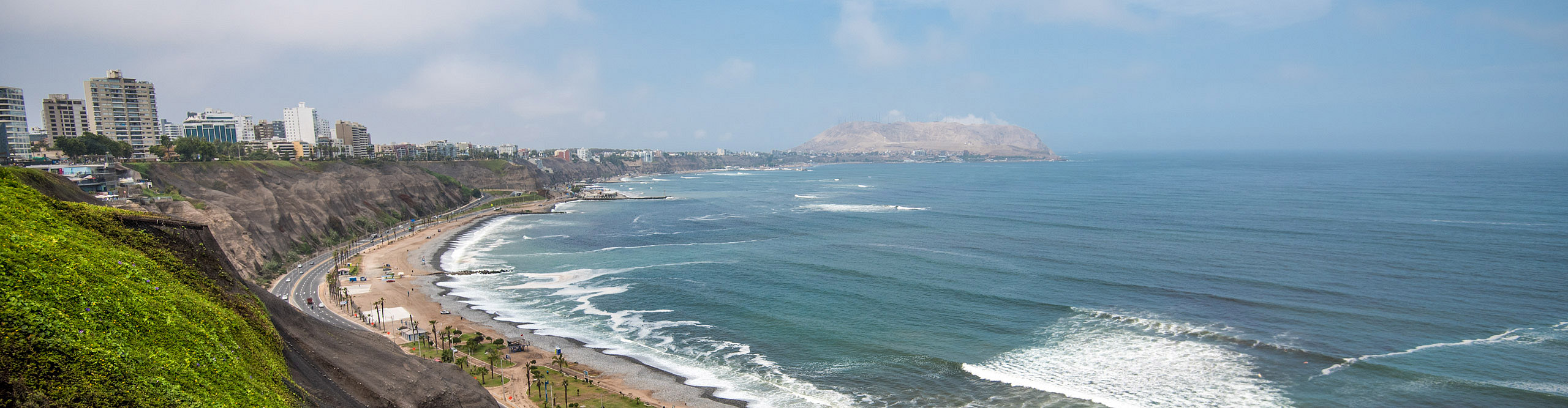 Vie3w of th3 coastline in Lima, Peru, with waves crashing and a clear sky, 