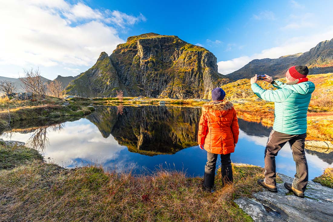 Travellers photographic Fjord on hike in Lofoten, Norway