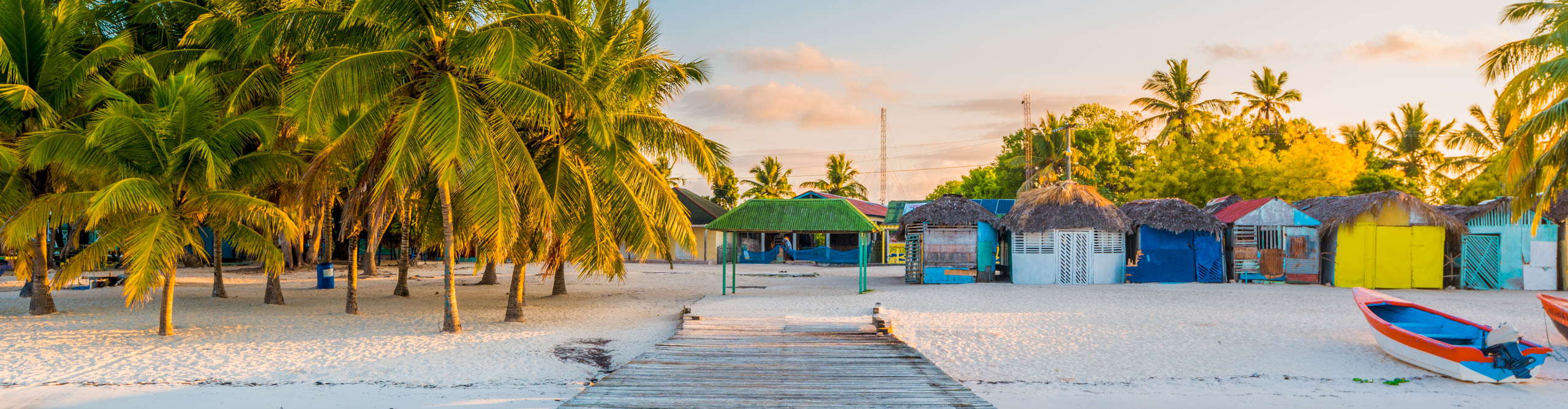 Wooden pier to a tropical beach, with colourful hits at sunset, Saona island, Dominican Republic 