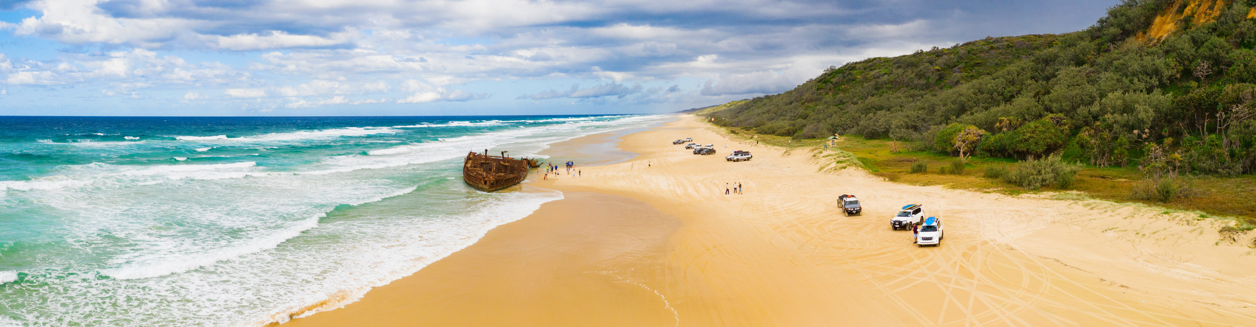 4x4 vehicles in the beach at Fraser Island, on a cloudy but sunny day, Queensland, Australia 