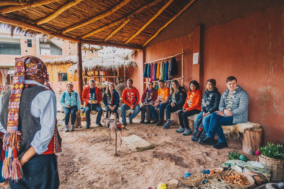 Leader and travellers enjoy a community visit with locals in Sacred Valley in Peru with Intrepid 