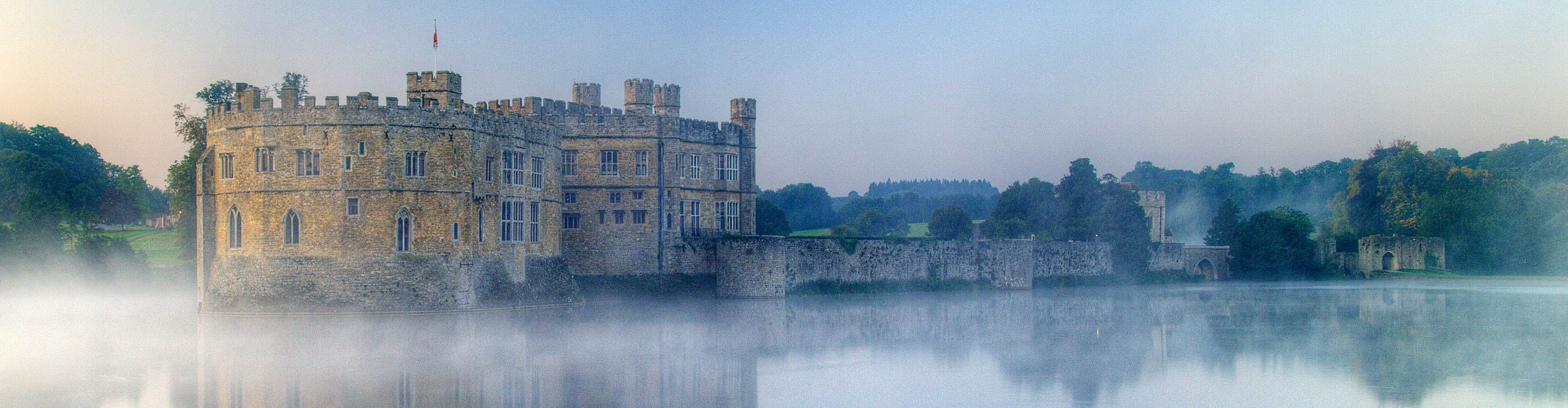 Leeds Castles reflected in the moat, in the morning mist, Kent, UK