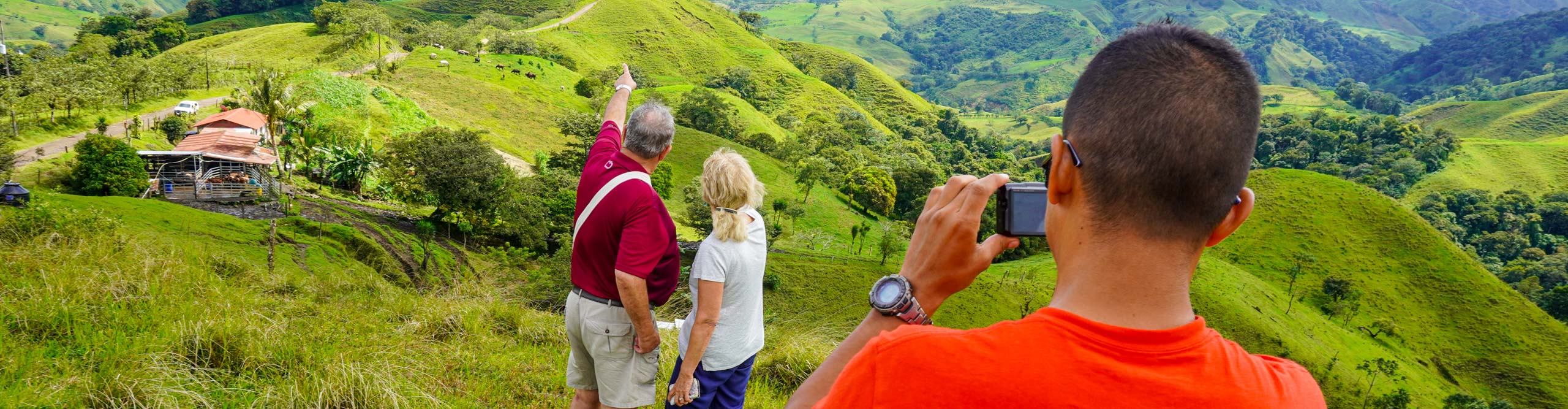 Couple looking out over hills with the guide taking their picture,  Costa Rica 