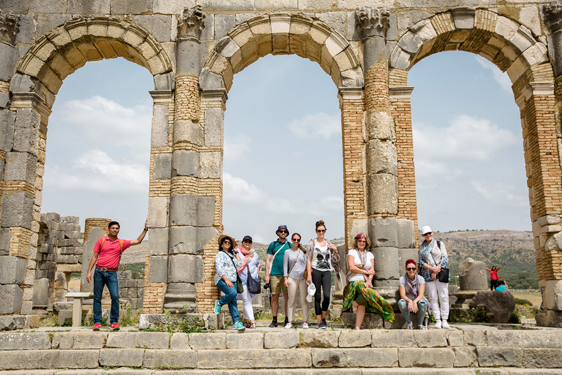 Intrepid Travel group posing under arch, Voulibis ruins, Morocco