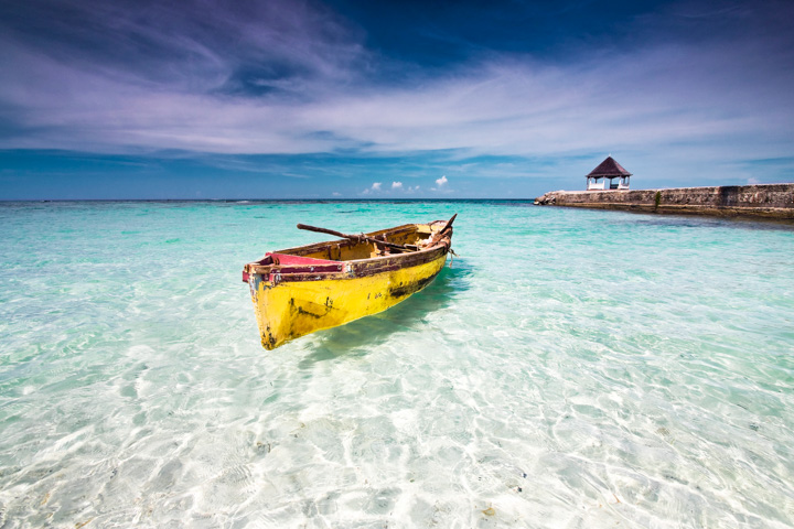 Fishing canoe docked at a beach in clear shallow water, north coast Jamaica, on a sunny day