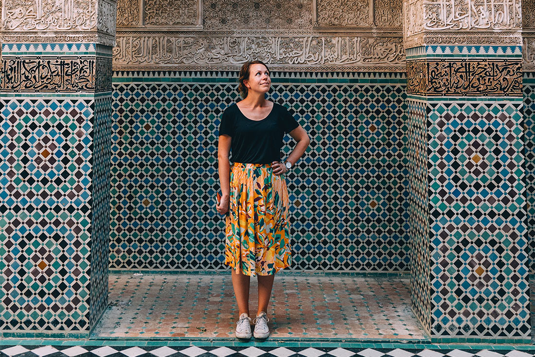 Traveller posing in front of colourful mosaic buildings in Fes, Morocco
