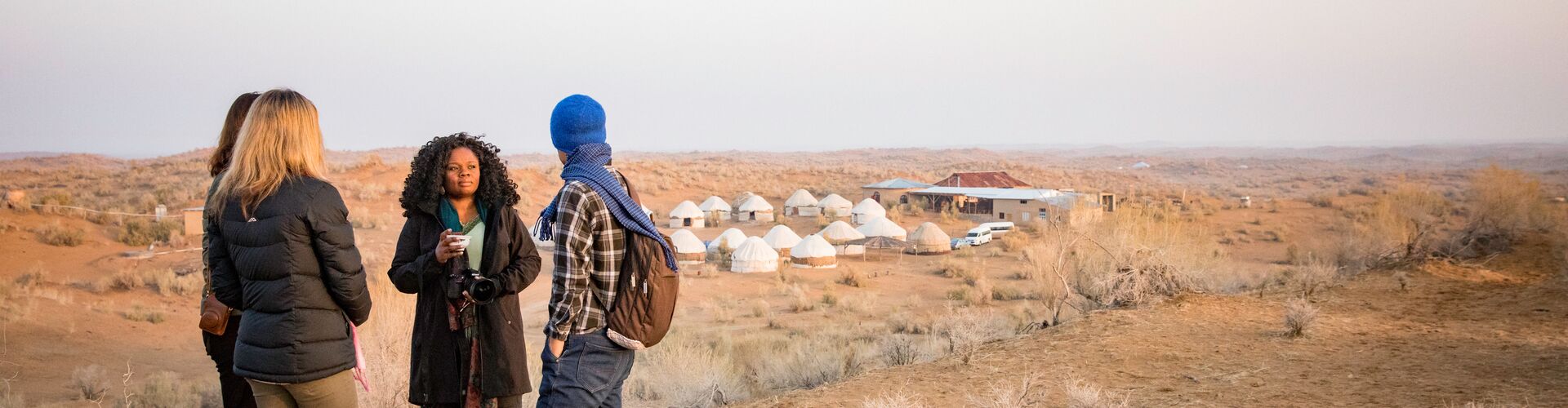 Travellers standing outside desert yurt camp, Uzbekistan