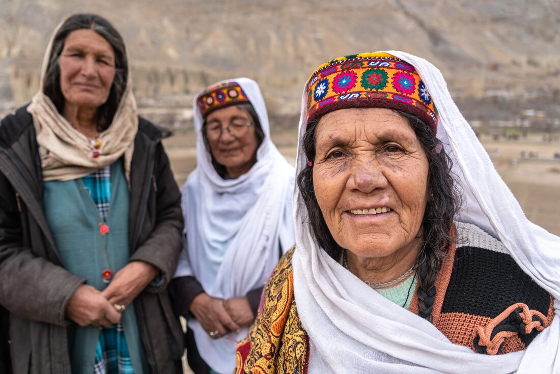 Local women in traditional dress smile for camera in Gilgit