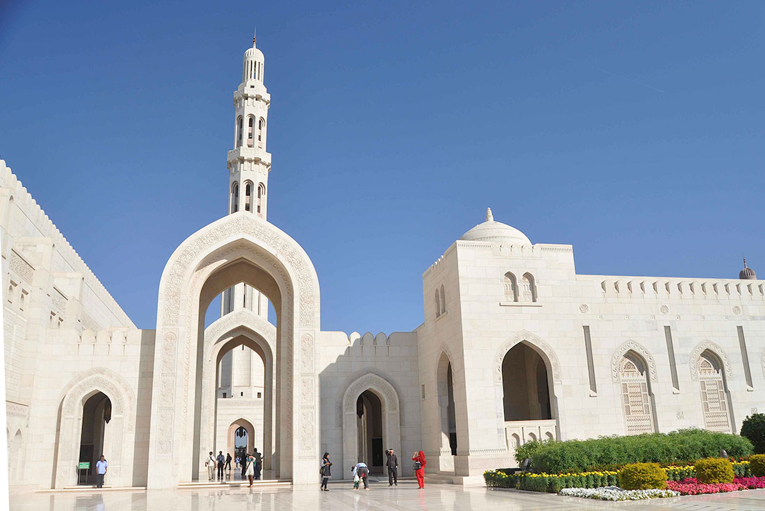 Exterior of the Grand Mosque in Muscat with travellers carrying through to the interior in Oman